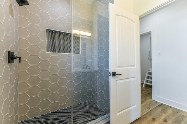 bathroom featuring a tile shower and hardwood / wood-style floors