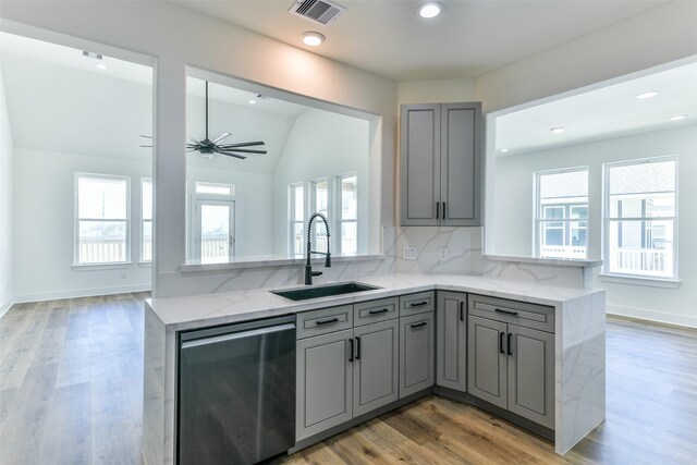 kitchen with dishwasher, kitchen peninsula, sink, and tasteful backsplash