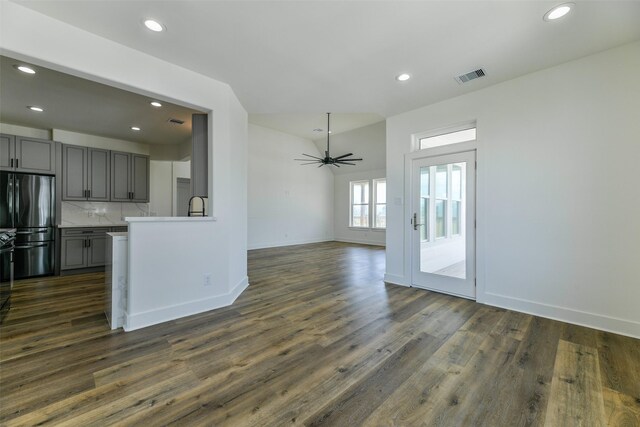 kitchen featuring stainless steel refrigerator, gray cabinetry, decorative backsplash, and dark hardwood / wood-style flooring