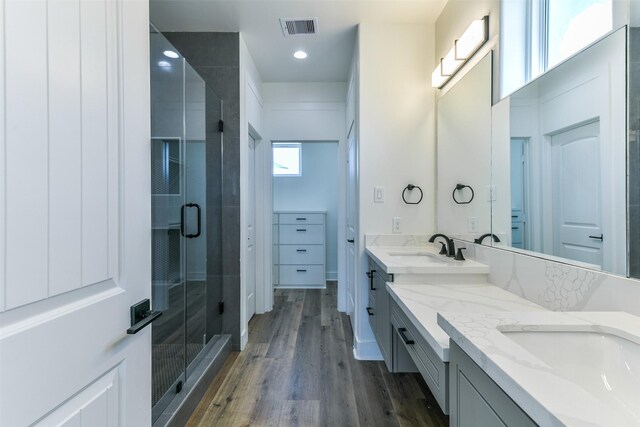 bathroom with vanity, hardwood / wood-style flooring, and a shower with door