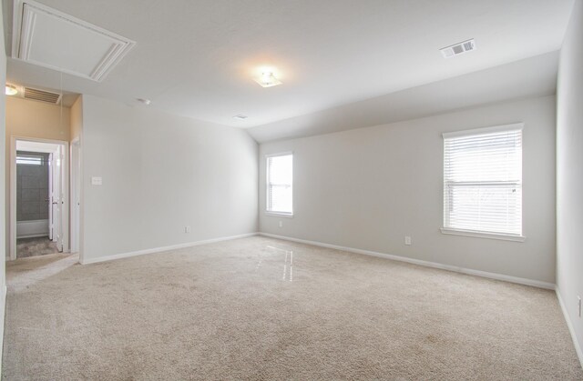 carpeted empty room with vaulted ceiling