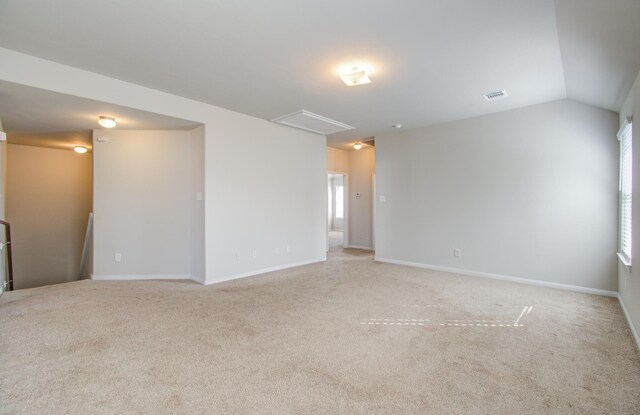 unfurnished room with light carpet and vaulted ceiling