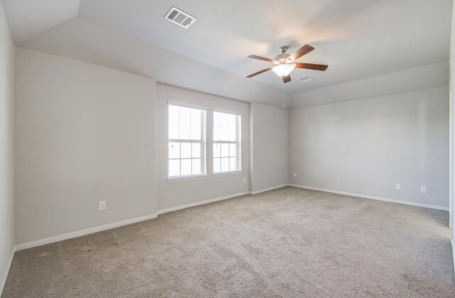 carpeted empty room featuring a raised ceiling and ceiling fan