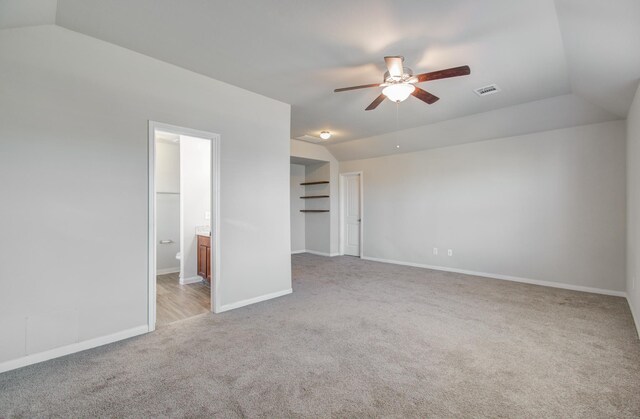 unfurnished bedroom featuring light carpet, ceiling fan, connected bathroom, a closet, and lofted ceiling