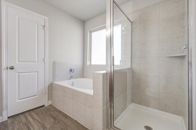 bathroom with hardwood / wood-style floors and shower with separate bathtub