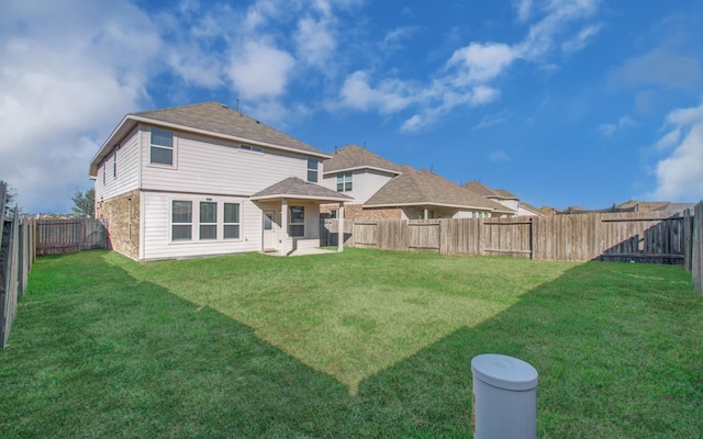 rear view of house featuring a yard and a patio