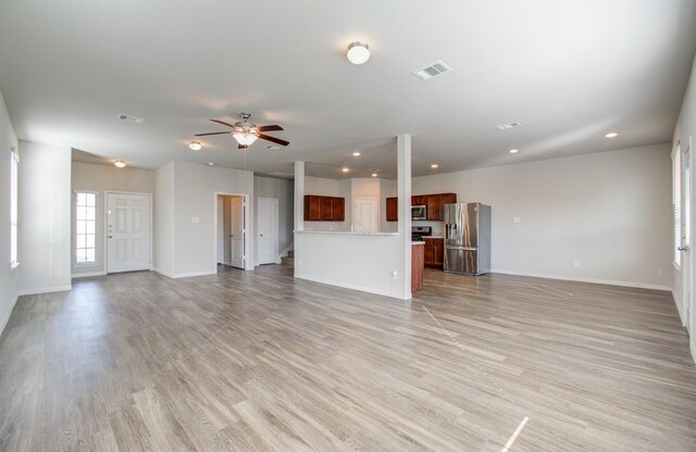 unfurnished living room with ceiling fan and light hardwood / wood-style floors