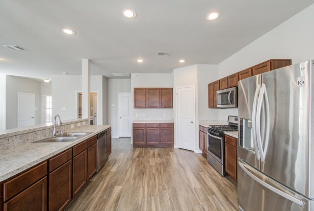 kitchen with light hardwood / wood-style floors, sink, and appliances with stainless steel finishes