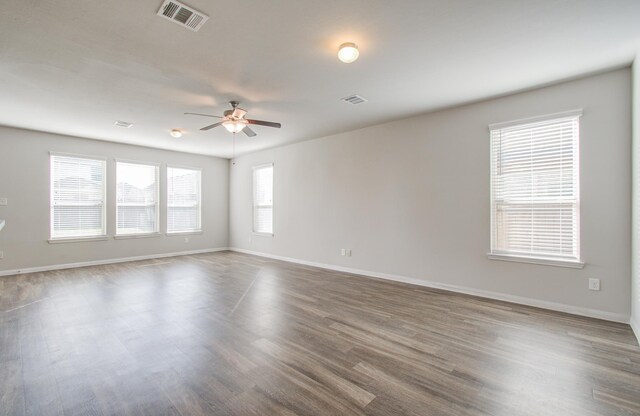 unfurnished room featuring wood-type flooring, ceiling fan, and a healthy amount of sunlight