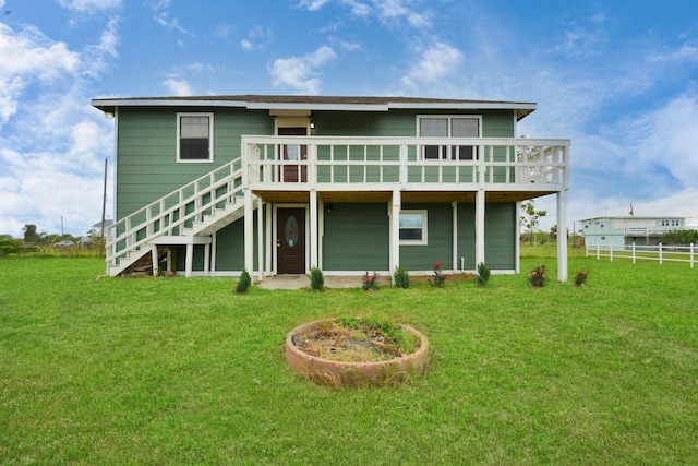 back of house featuring a lawn and a deck