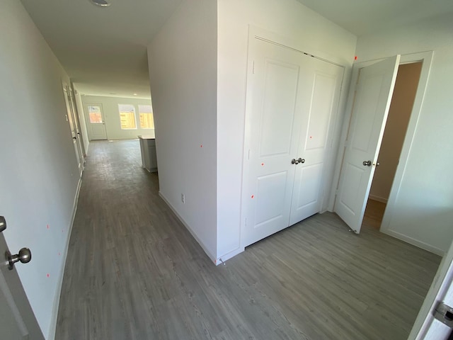 corridor with baseboards and wood finished floors