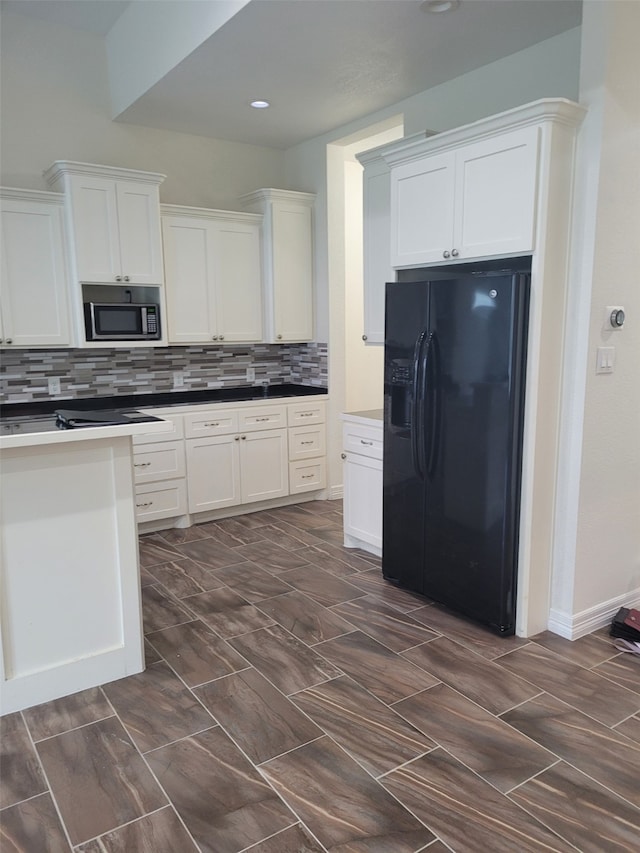 kitchen featuring white cabinets, backsplash, black fridge, and built in microwave