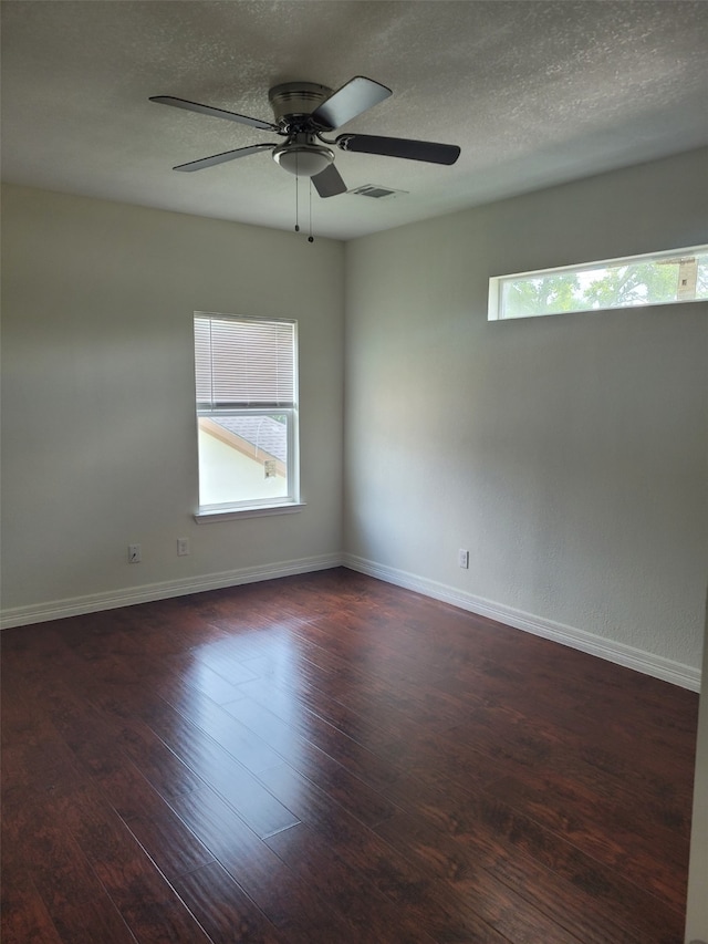 unfurnished room featuring ceiling fan, dark wood-type flooring, and a textured ceiling