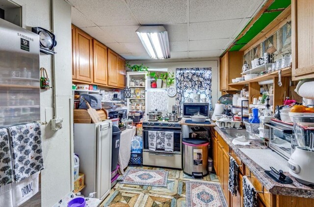 kitchen with a paneled ceiling and appliances with stainless steel finishes