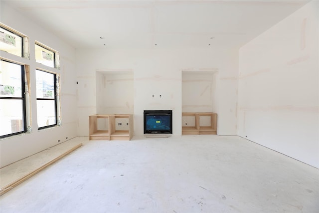 1439 Martin St, Houston, TX 77018 - unfurnished living room with a glass covered fireplace, unfinished concrete flooring, and heating unit