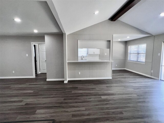 unfurnished living room with vaulted ceiling with beams, sink, and dark hardwood / wood-style floors