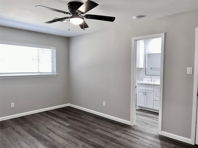 unfurnished room featuring dark hardwood / wood-style floors, ceiling fan, and sink