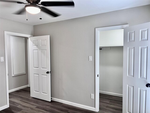 unfurnished bedroom featuring dark hardwood / wood-style flooring, ceiling fan, and a closet