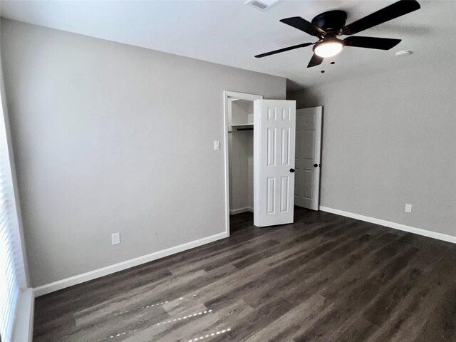 unfurnished bedroom with ceiling fan, a closet, and dark hardwood / wood-style floors