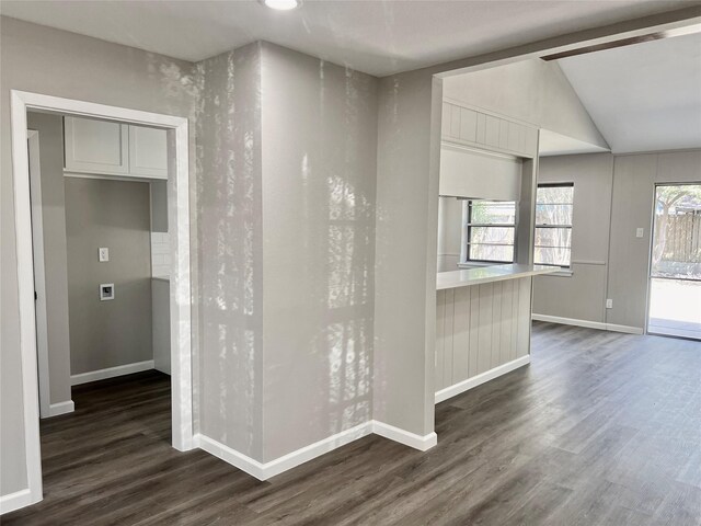 empty room featuring dark wood-type flooring and vaulted ceiling