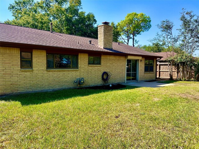 rear view of house featuring a lawn