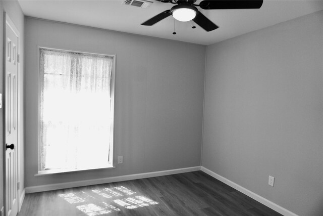 empty room featuring ceiling fan and dark wood-type flooring