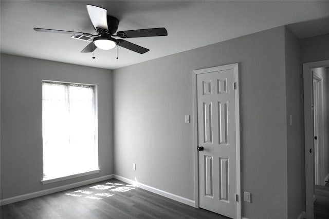 spare room with dark hardwood / wood-style floors and ceiling fan