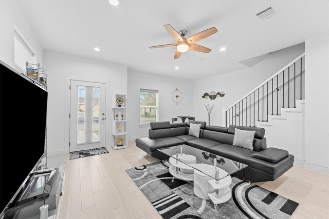 living room featuring ceiling fan and light hardwood / wood-style floors