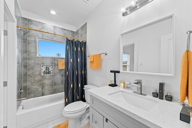 full bathroom with shower / bath combo with shower curtain, vanity, plenty of natural light, and toilet