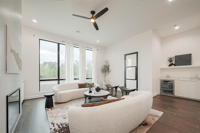 living room with ceiling fan, dark hardwood / wood-style floors, beverage cooler, and a fireplace