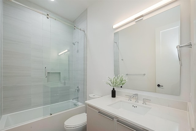 full bathroom with bath / shower combo with glass door, toilet, and vanity