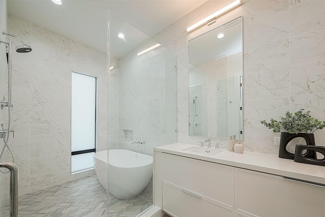 bathroom with plus walk in shower, tile walls, and vanity