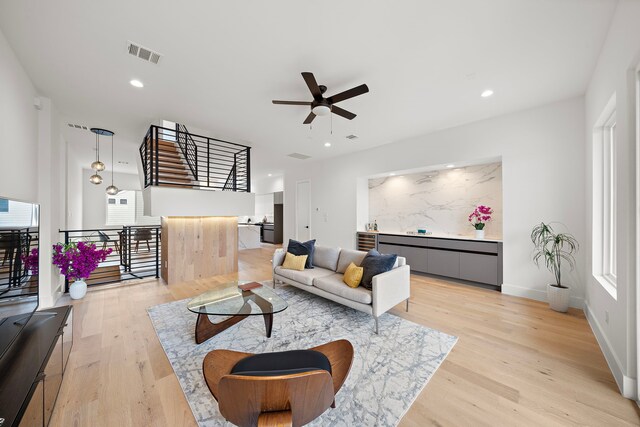 living room with a healthy amount of sunlight, ceiling fan, and light hardwood / wood-style floors