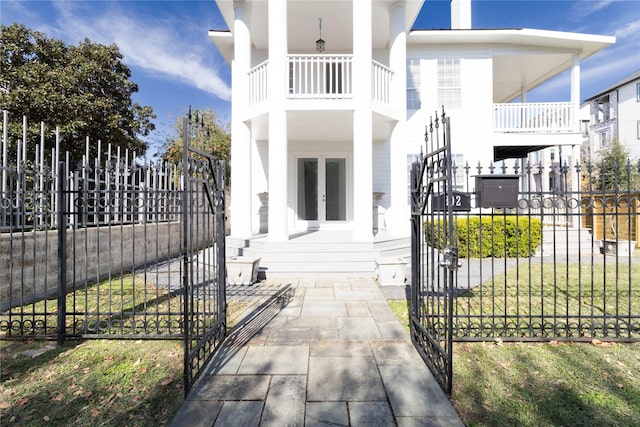 view of front facade with french doors and a balcony