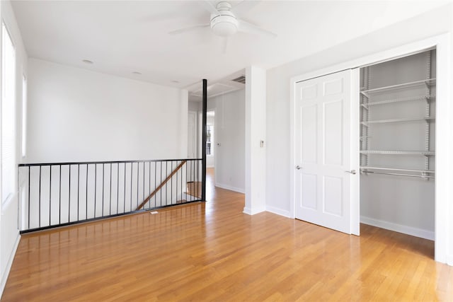 unfurnished bedroom featuring light hardwood / wood-style floors, a closet, and ceiling fan