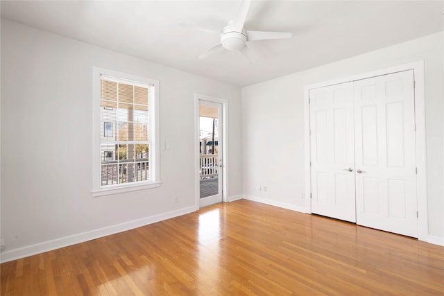 unfurnished bedroom featuring hardwood / wood-style floors, a closet, ceiling fan, and access to exterior