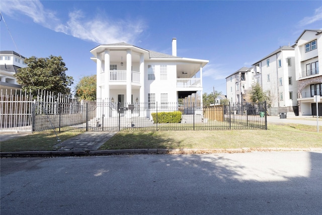 view of front facade featuring a balcony and a front yard