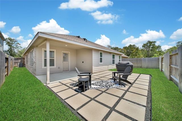 rear view of house featuring a patio area, a yard, and central AC