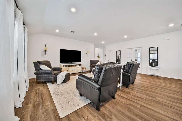 living room with vaulted ceiling and hardwood / wood-style flooring