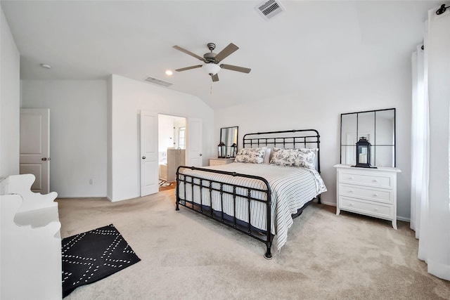 bedroom featuring ensuite bath, ceiling fan, light carpet, and vaulted ceiling