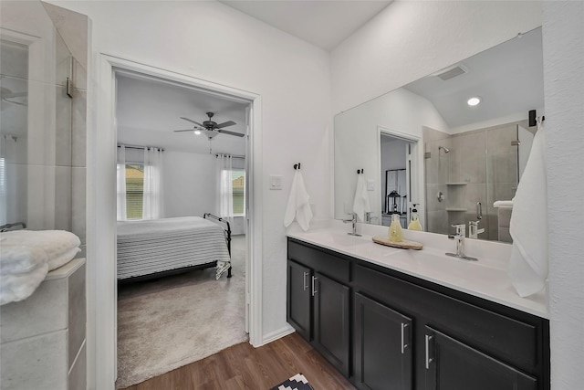 bathroom with ceiling fan, walk in shower, hardwood / wood-style floors, vaulted ceiling, and vanity