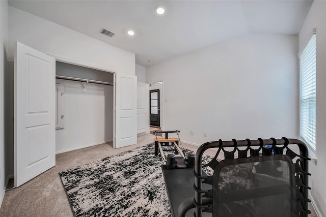 carpeted bedroom with a closet and lofted ceiling