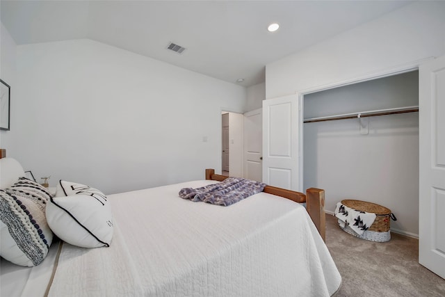 carpeted bedroom featuring vaulted ceiling and a closet