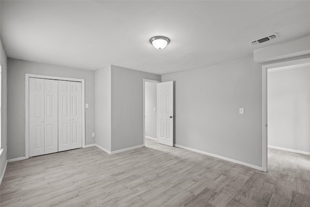 unfurnished bedroom with a closet and light hardwood / wood-style floors