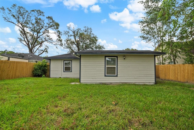 back of property with a lawn