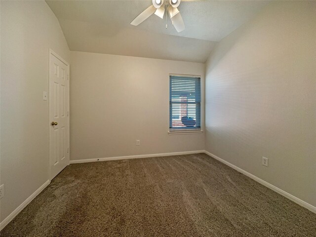 carpeted spare room featuring vaulted ceiling and ceiling fan