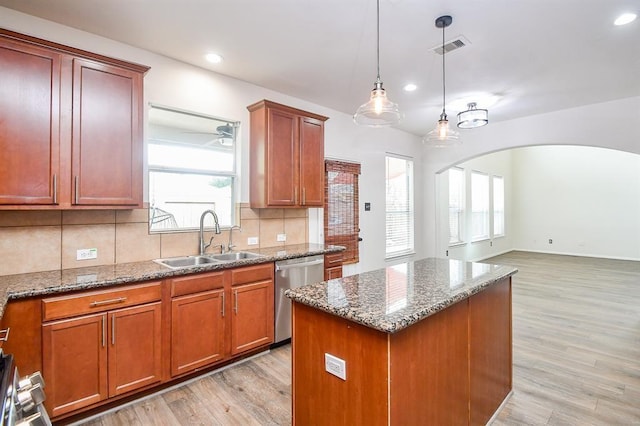 kitchen with dishwasher, a kitchen island, light hardwood / wood-style floors, and sink