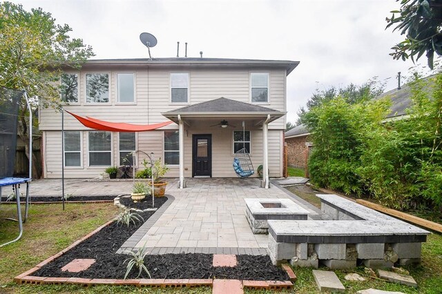 back of property featuring ceiling fan, a patio, and a trampoline