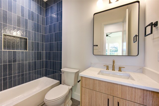 full bathroom featuring vanity, toilet, ceiling fan, and tiled shower / bath combo