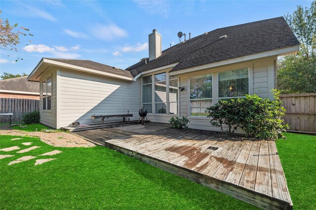 back of house featuring a lawn and a deck